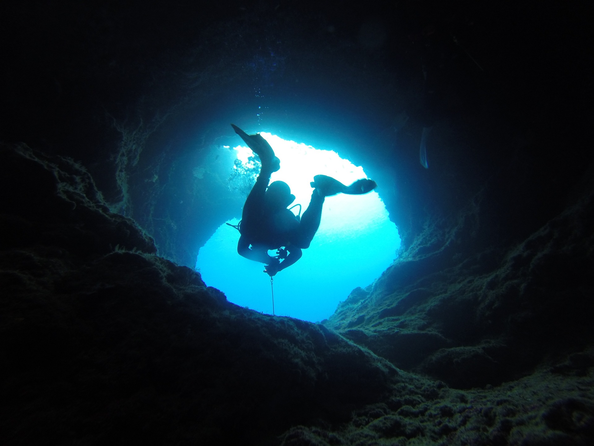 Looking up at a diver through a cavern swimthrough